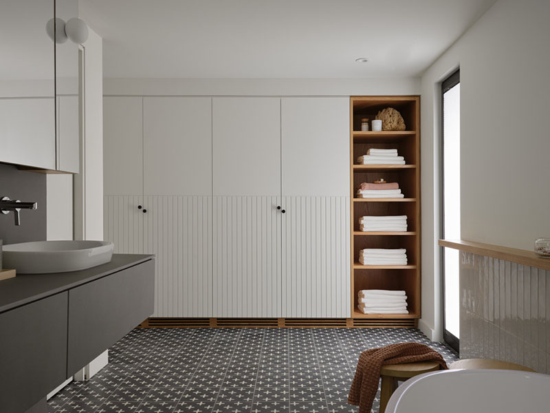Baño de Barbora Vokac Taylor Architect con mobiliario en tonos neutros y baldosas estampadas