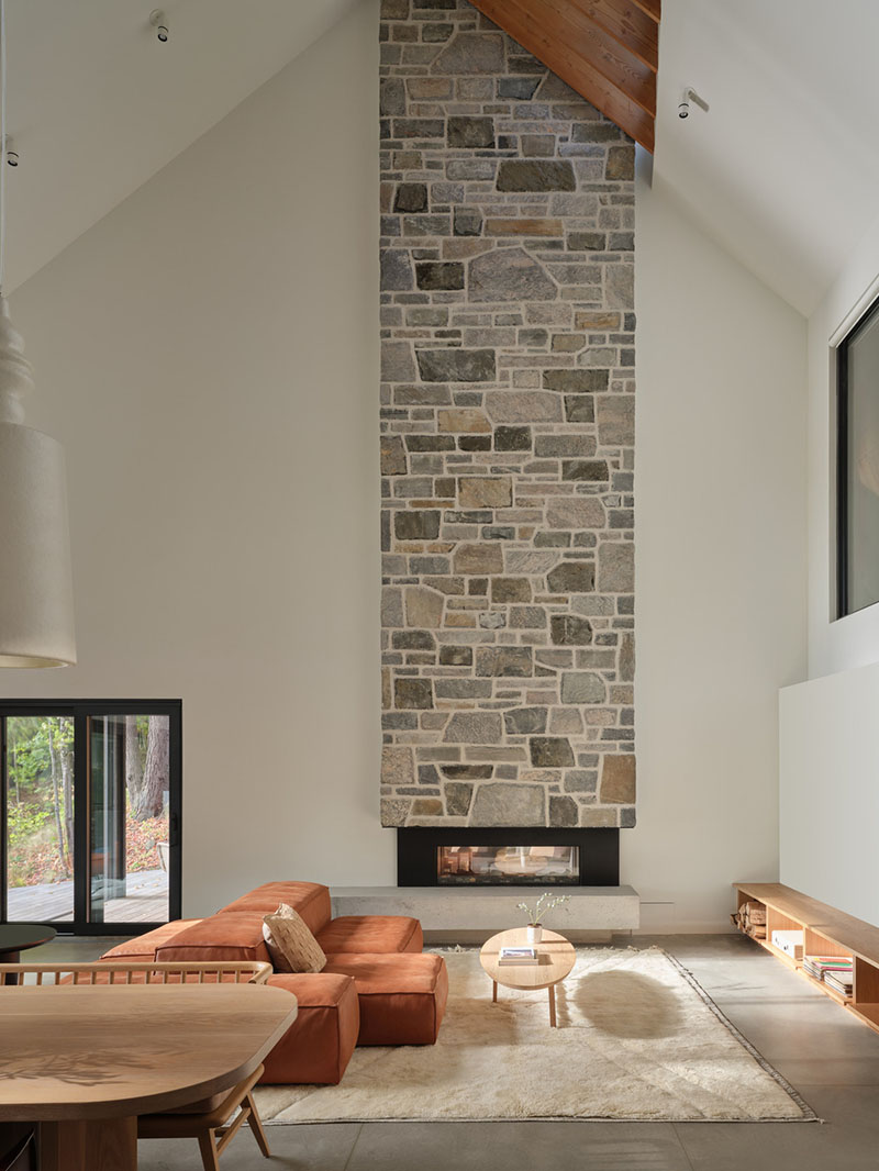 Sala de Barbora Vokac Taylor Architect con chimenea de piedra a doble altura