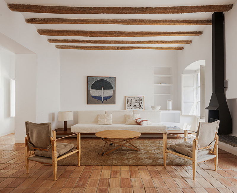 Sala de estar con vigas de madera vistas y mobiliario diseñado por Bea Portabella y Jordi Pagès