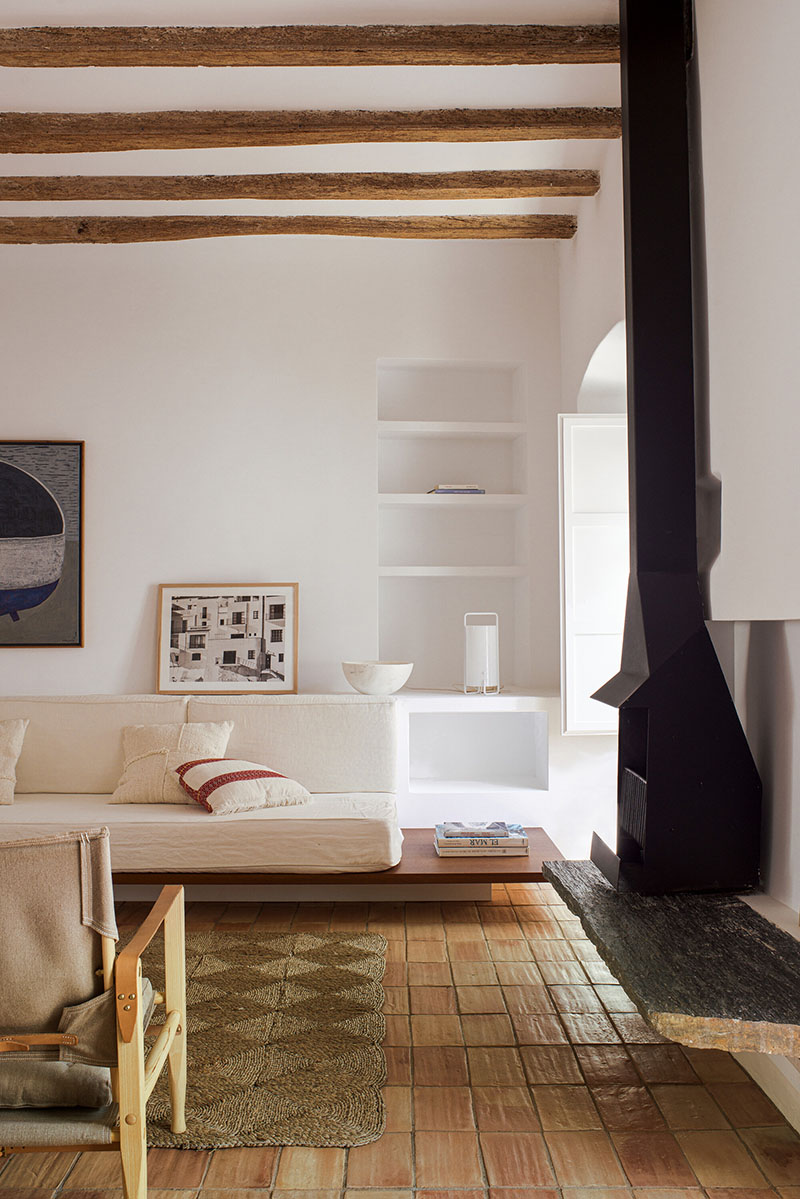 Detalle del salón con chimenea metálica y estanterías integradas por Bea Portabella y Jordi Pagès
