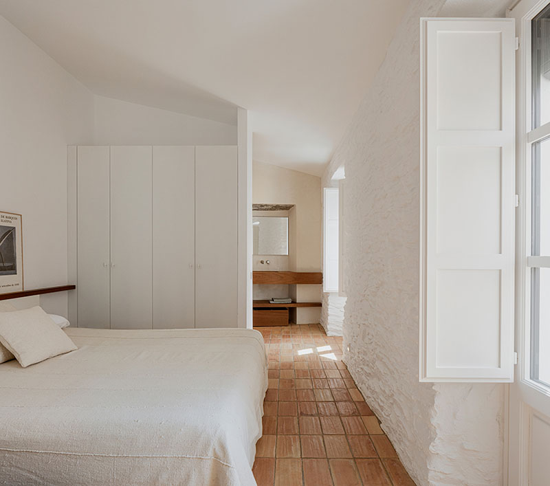 Dormitorio principal con muros encalados y mobiliario integrado de Bea Portabella y Jordi Pagès