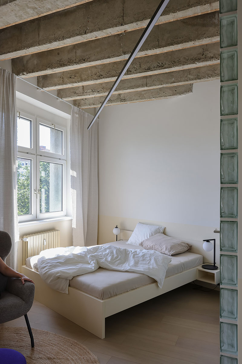 Dormitorio del Metropol con bloques de vidrio y techo expuesto, proyecto de Beed Architekti