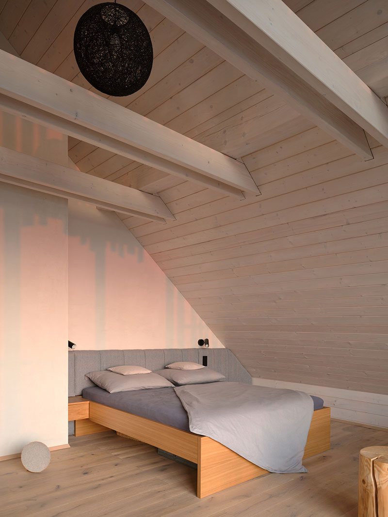 Dormitorio abuhardillado de Senaa con cama doble y techo de madera pintada en blanco