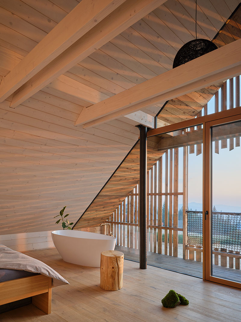 Dormitorio principal de Senaa con bañera exenta junto a terraza acristalada