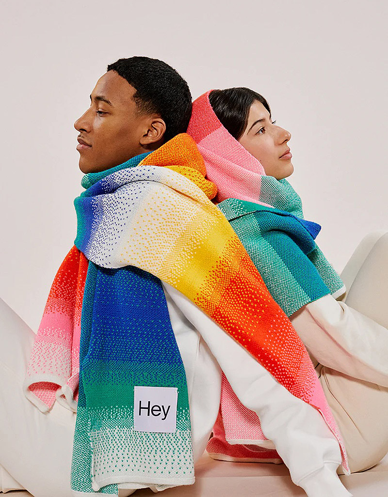 Imagen de dos personas unidas por la misma bufanda de colores.