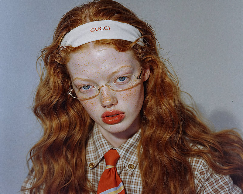 Imagen de mujer pelirroja con gafas y cinta gucci