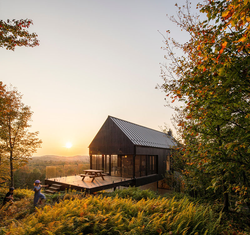 Vista posterior al atardecer de la vivienda Le Noroît diseñada por Guillaume Pelletier Architecte