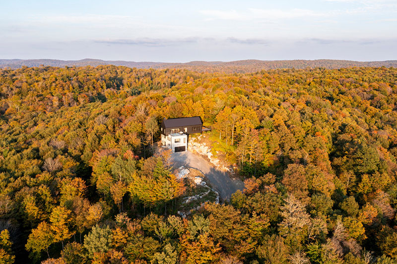 Vista aérea de la vivienda Le Noroît de Guillaume Pelletier Architecte integrada en el bosque de los montes laurentinos