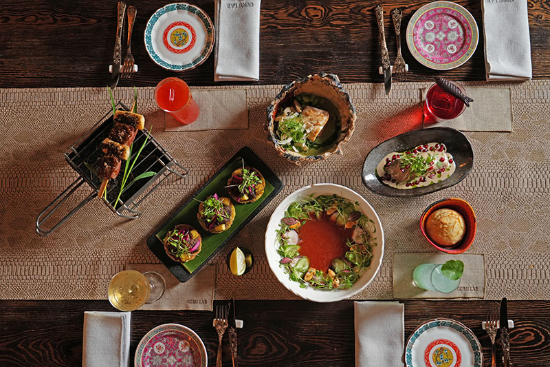 Mesa de la nueva temporada de Guru Lab con varios platos y cócteles