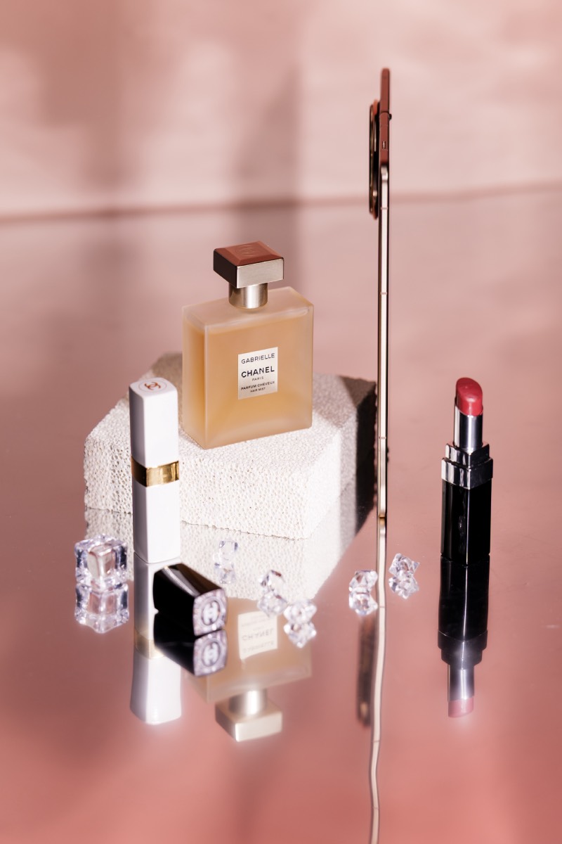 Honor Magic V5: smartphone Honor Magic V5 camuflado entre productos de belleza en una foto de estudio sobre un fondo en tonos rosas.