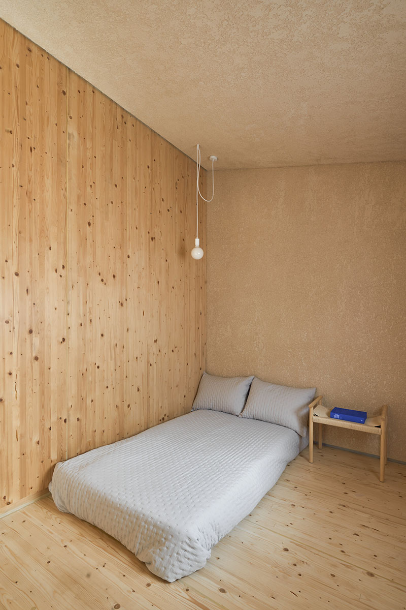 Dormitorio con revestimiento de madera de Made V Arquitectos