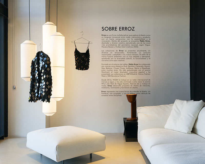 Prendas de Erroz cuelgan junto a lámparas en la exposición de Minim
