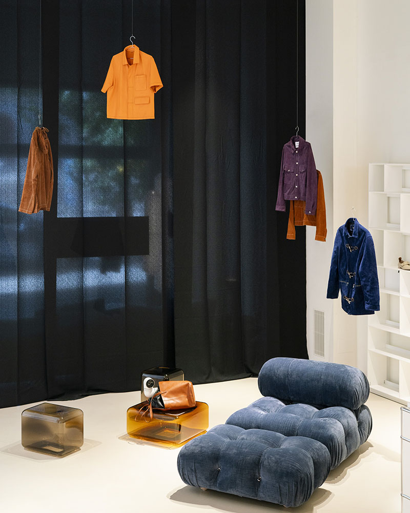 Camisas y pantalones de Erroz se muestran en la exposición de Minim junto a piezas de mobiliario