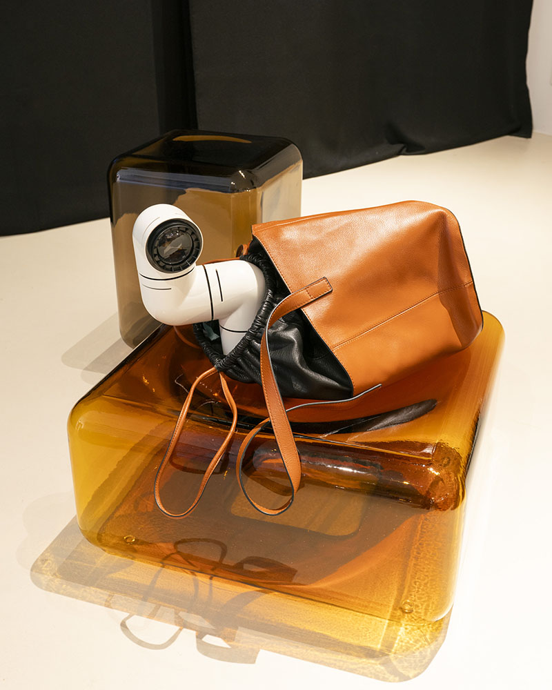 Un bolso de Erroz se exhibe en la exposición de Minim sobre cubos de vidrio
