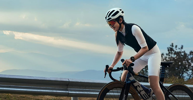 Mujer montando en bici lleva el Oppo Watch X2 en la muñeca