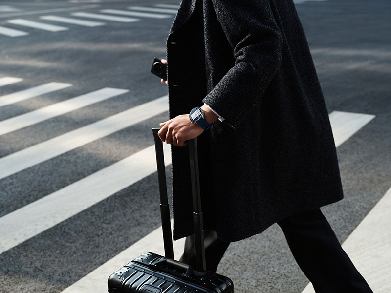 Oppo Watch X2 un señor con abrigo y maleta lleva en su muñeca el reloj