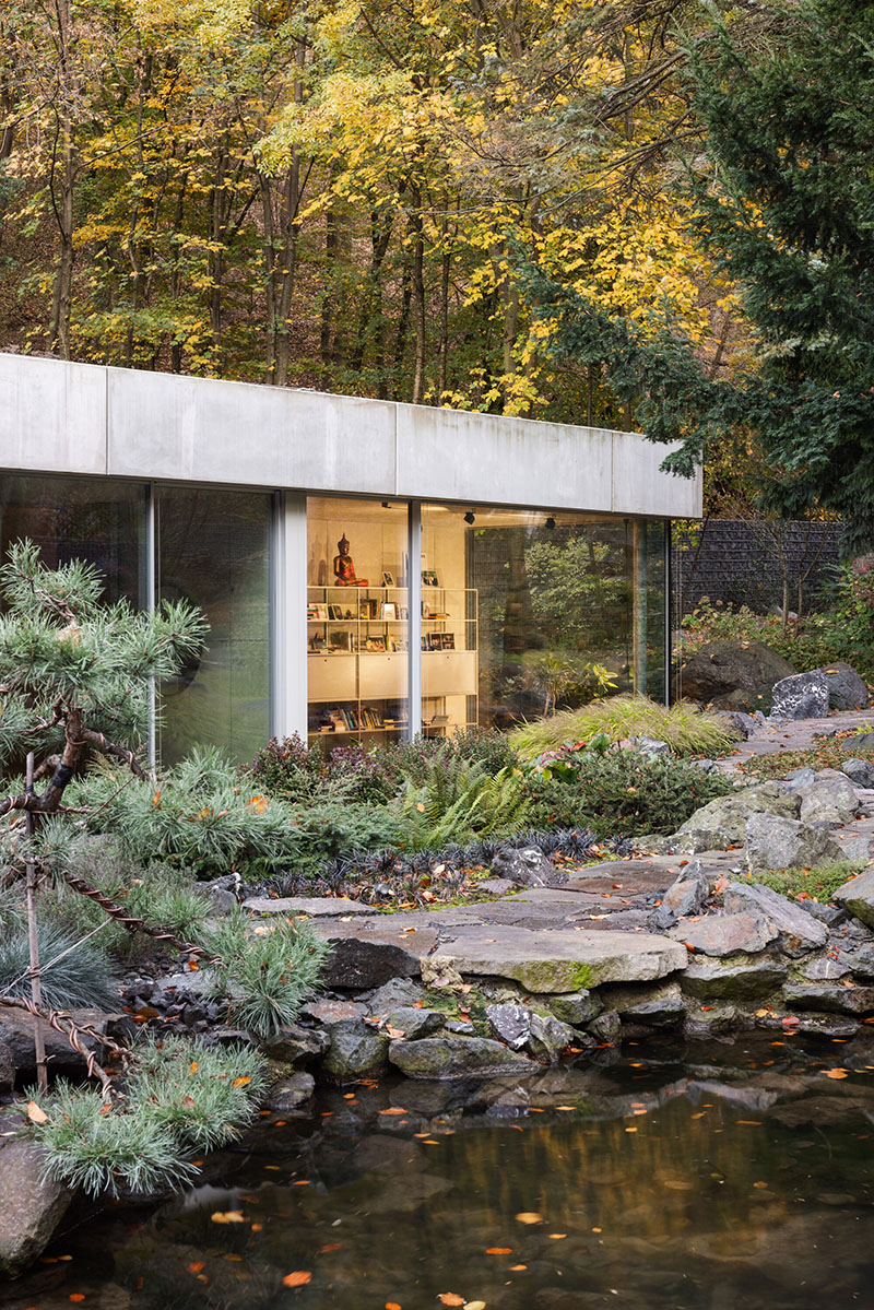 Fachada de Banánka de Paulíny Hovorka Architects con biblioteca acristalada frente al estanque