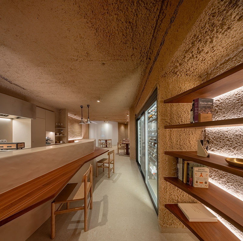 Barra del restaurante Tándem, Murcia, diseño de Laura Ortín con estanterías y refrigerador vistos desde el pasillo