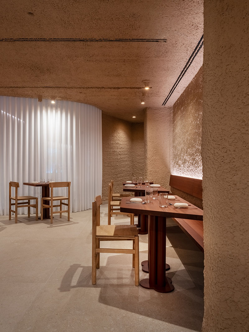 Sala del restaurante Tándem, Murcia, proyecto de Laura Ortín con mesas alineadas junto a cortina blanca curva