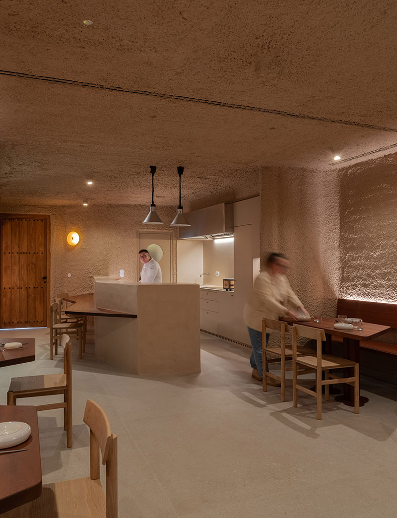 Cocina abierta del restaurante Tándem, Murcia, diseño de Laura Ortín con barra central y zona de mesas en primer plano