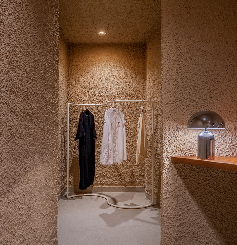 Vestidor del restaurante Tándem, Murcia, proyecto de Laura Ortín con perchas para uniformes y lámpara metálica