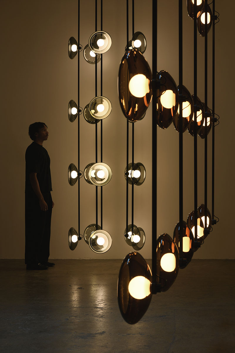 La repetición rítmica de las luminarias de Clair-obscur de Ronan Bouroullec se aprecia en la galería Kreo desde una vista oblicua