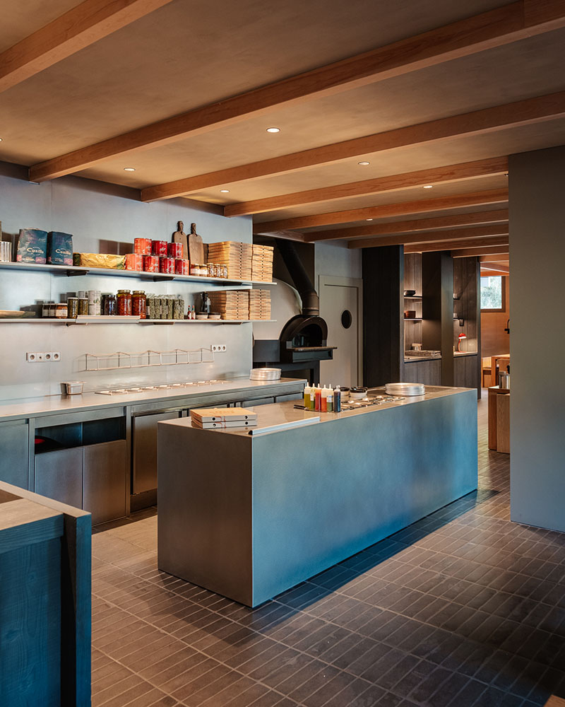 Cocina vista con horno y barra de servicio en Fora Pizza de Sandra Tarruella