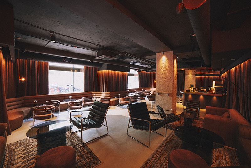 Interior de Snake Bar en Madrid con sofás, butacas y barra iluminada