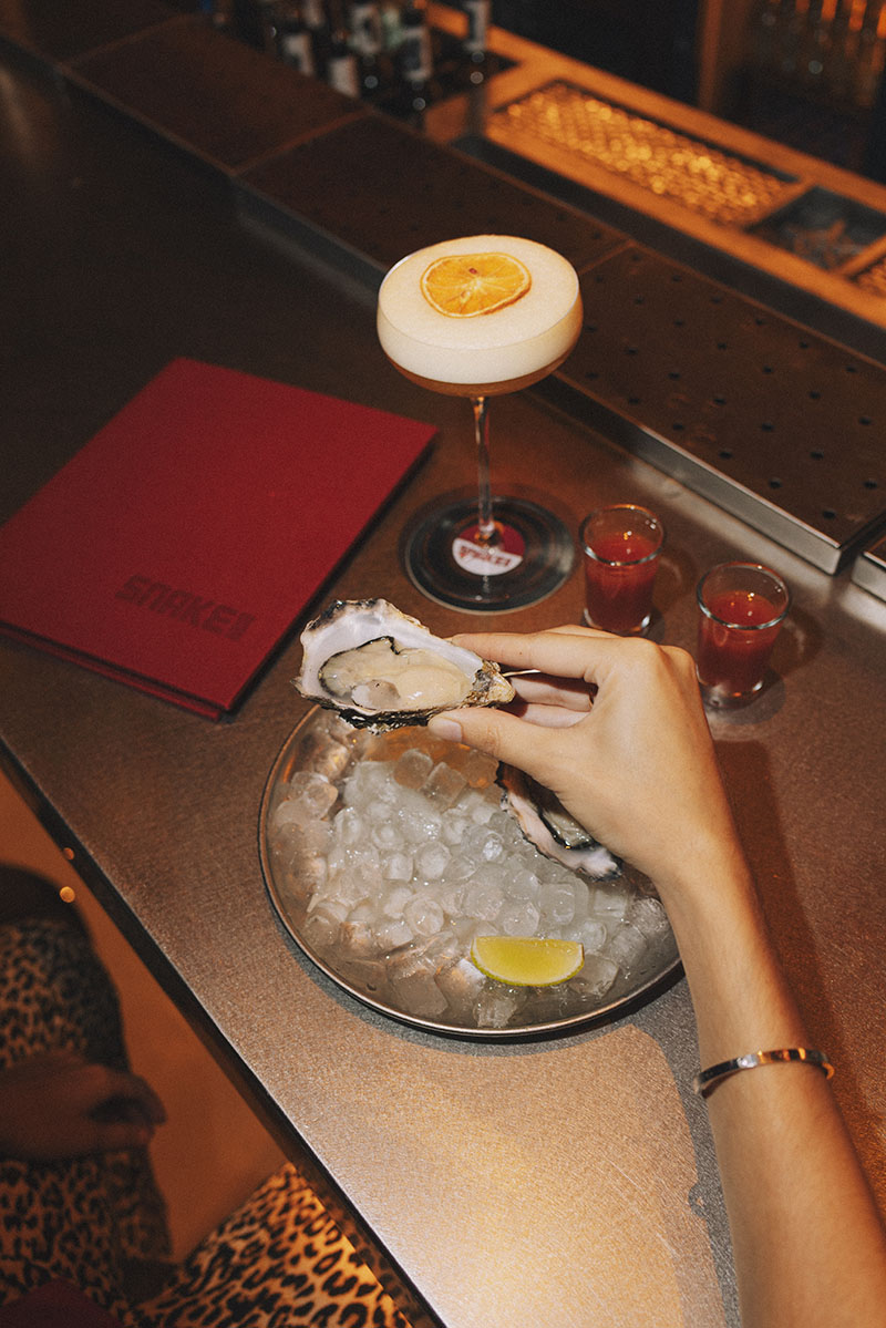 Ostra con aliño y cóctel en la barra de Snake Bar Madrid