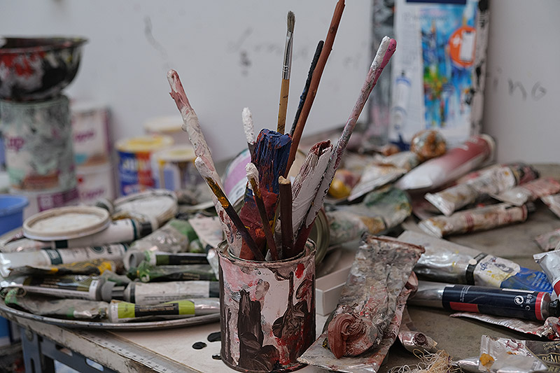 cuadro al óleo de Carlos León - estudio de artista con pinceles y pinturas