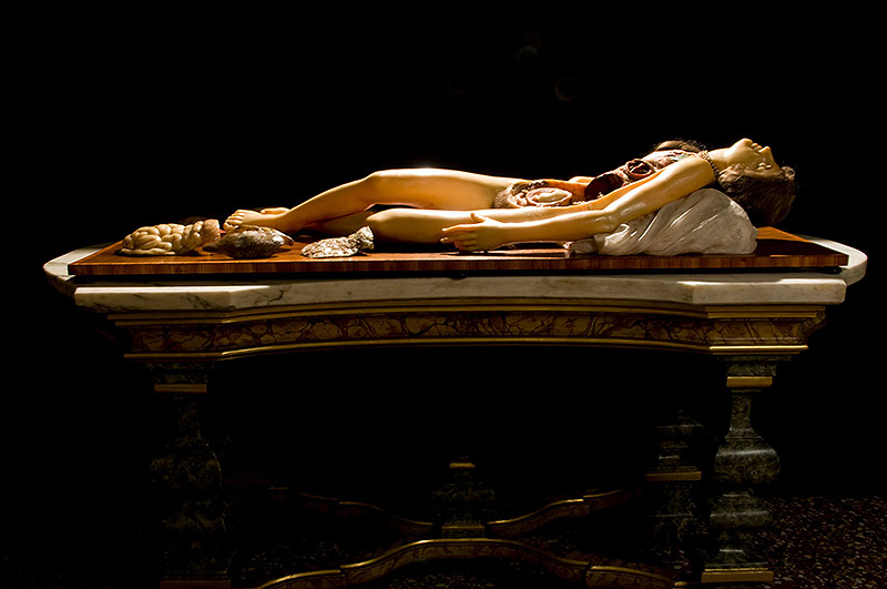 Imagen de una mujer tumbada como si fuera una escultura