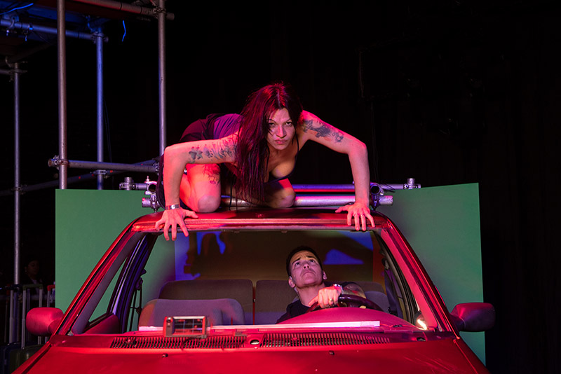 Imagen de una mujer sobre un coche rojo