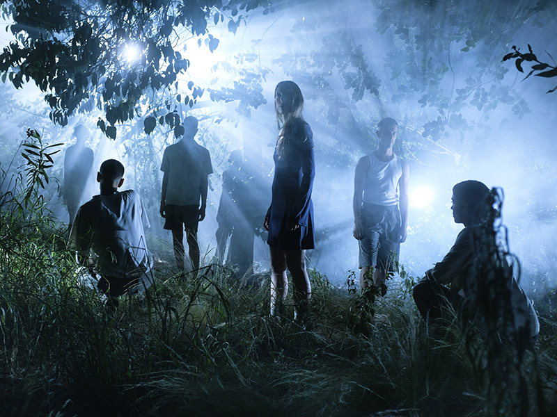 Imagen de jóvenes en un bosque en la oscuridad