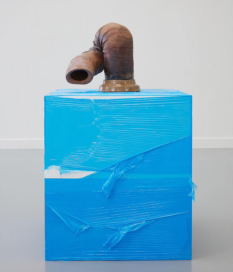 Escultura de tubo sobre plataforma azul