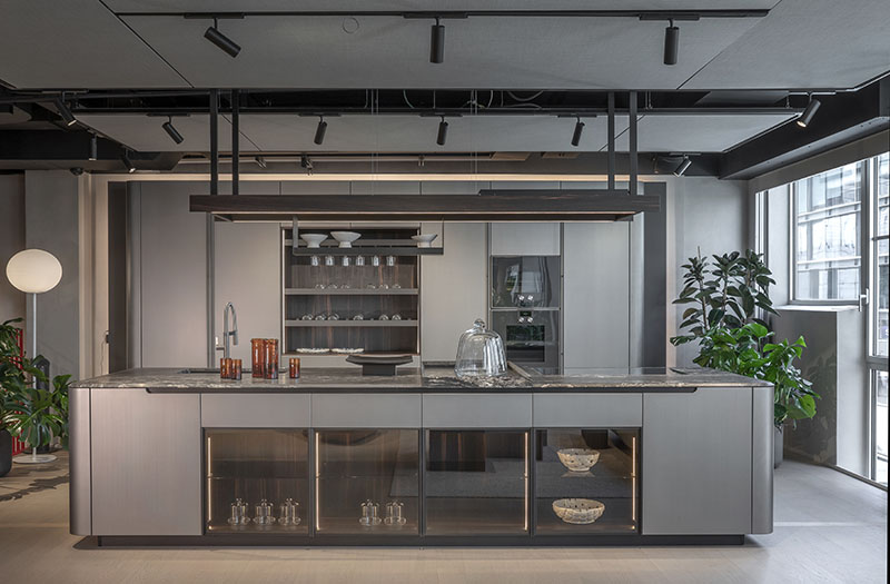 Vista general de la cocina metálica con formas curvas de Arrital, con isla central y mobiliario de acabado satinado
