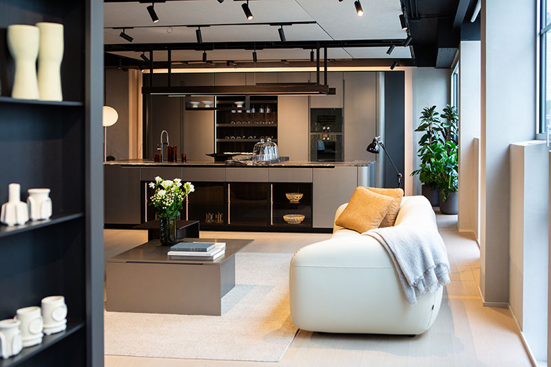 Ambiente doméstico con la cocina metálica con formas curvas de Arrital integrada en el espacio de estar