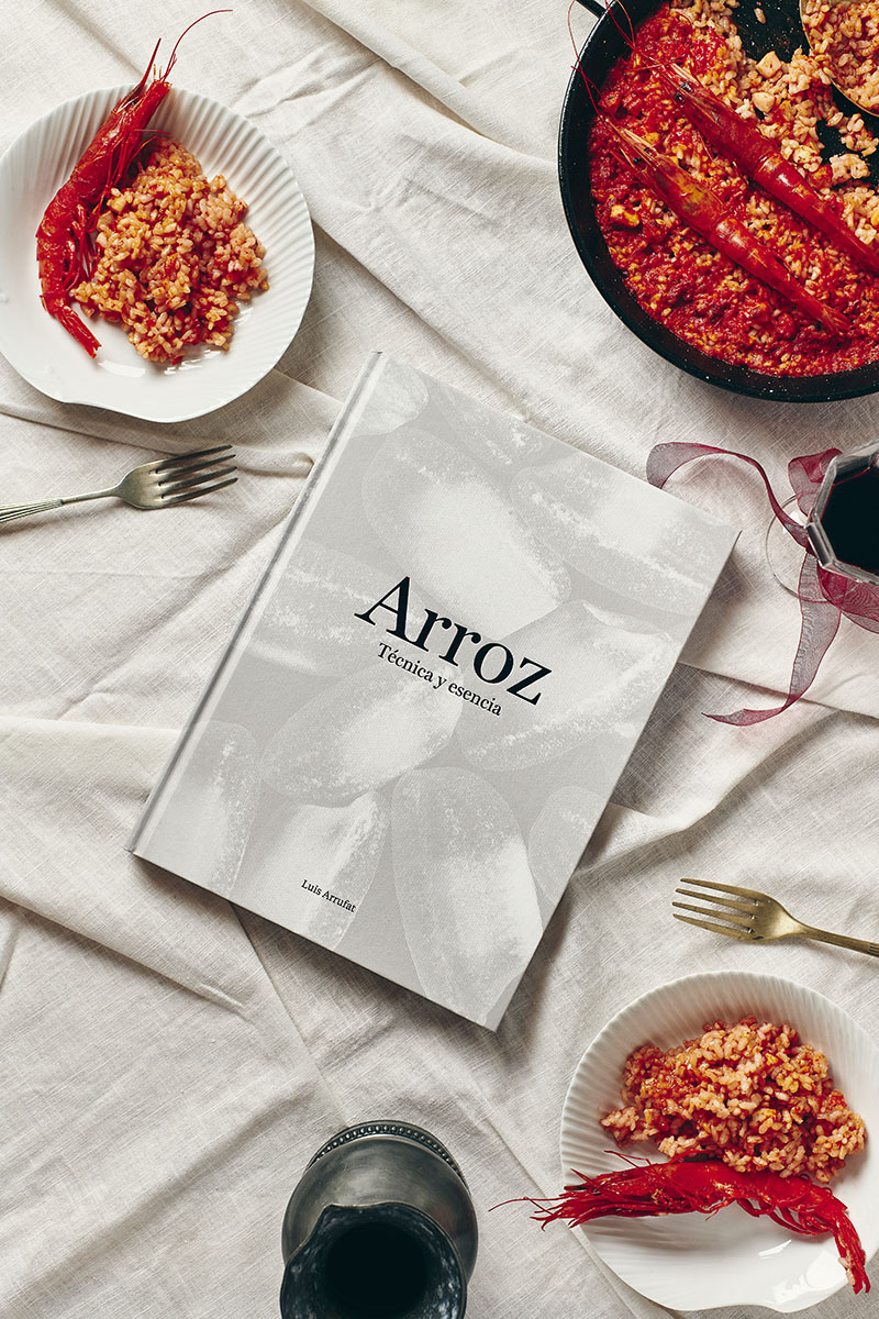 Portada del libro Arroz. Técnica y esencia de Luis Arrufat junto a un plato de arroz con gambas