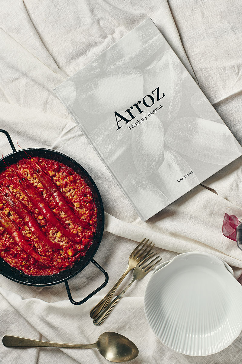 Cubierta de Arroz. Técnica y esencia de Luis Arrufat junto a una paella con gambas rojas