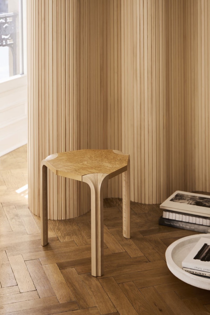 Artek: taburete Stool X602 sobre un parqué de madera y junto a un biombo de Artek.
