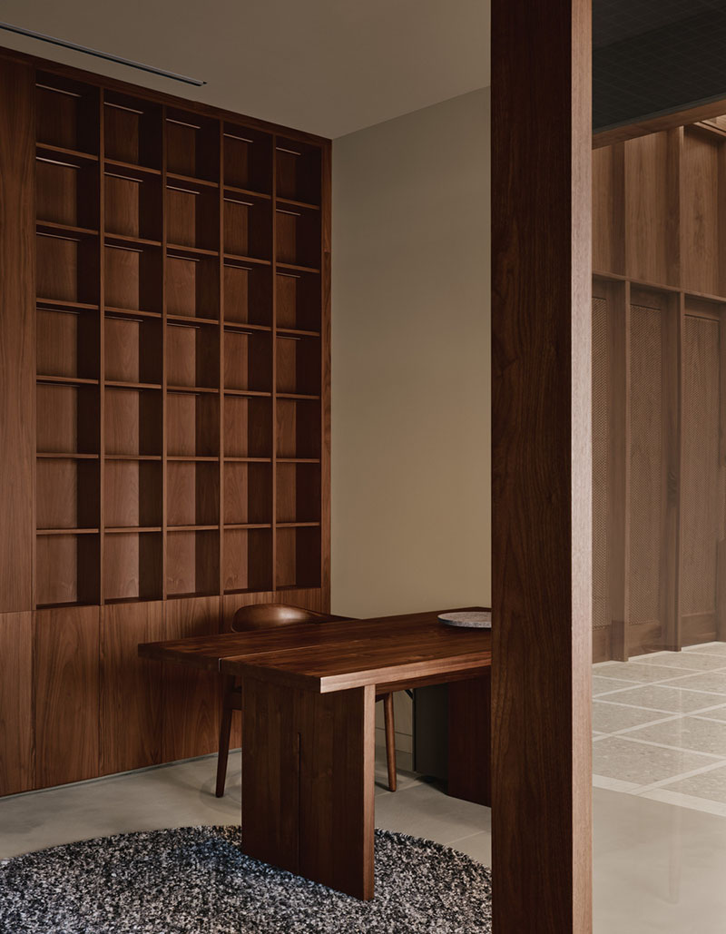 AtelierCarle Oakv: recepción con escritorio y panelado de nogal visto desde el área común
