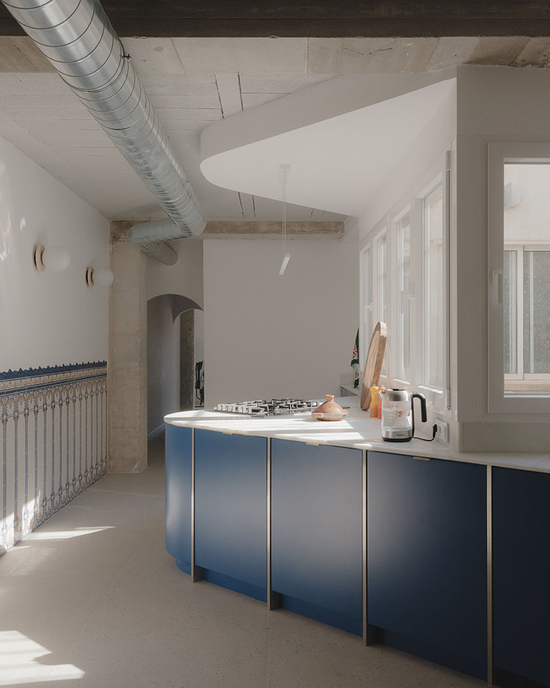 Vista lateral de la cocina de Maria Aucejo, arquitecta, en el dúplex en Alboraia con encimera curva y zócalo alicatado