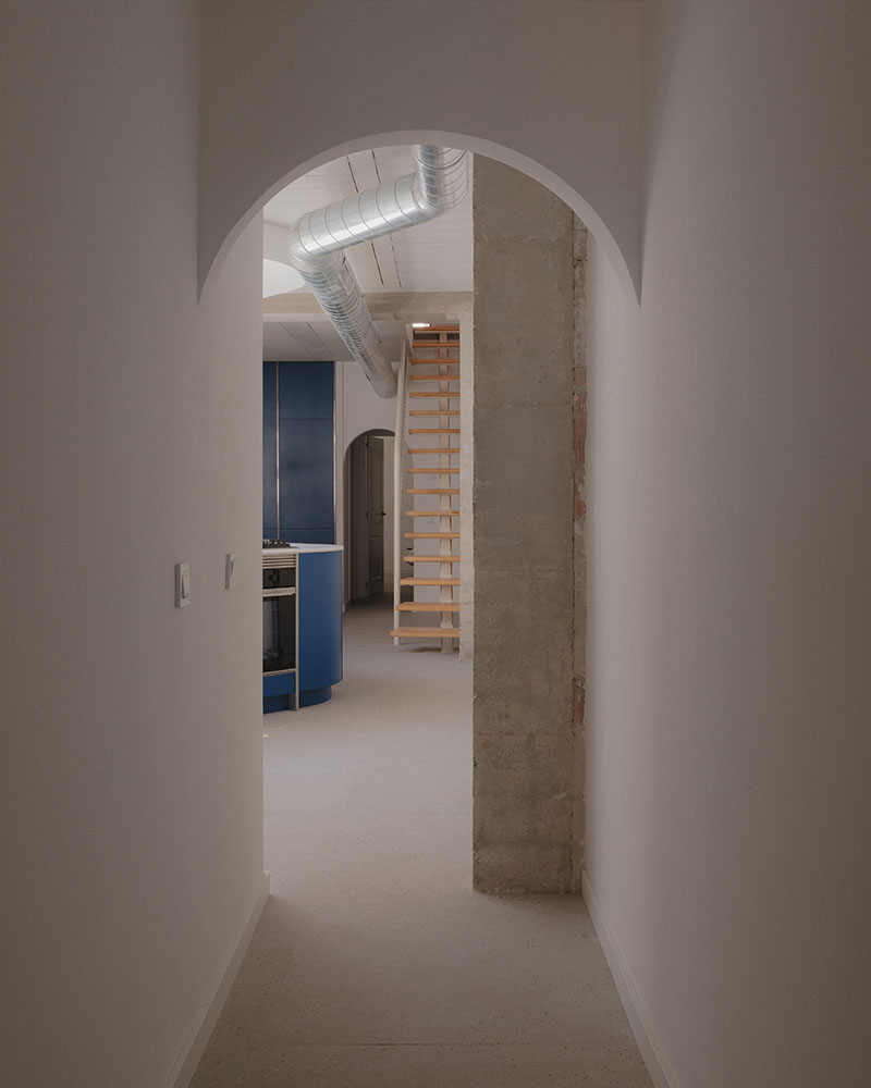 Pasillo proyectado por Maria Aucejo, arquitecta, en el dúplex en Alboraia con arco y conducto metálico visto