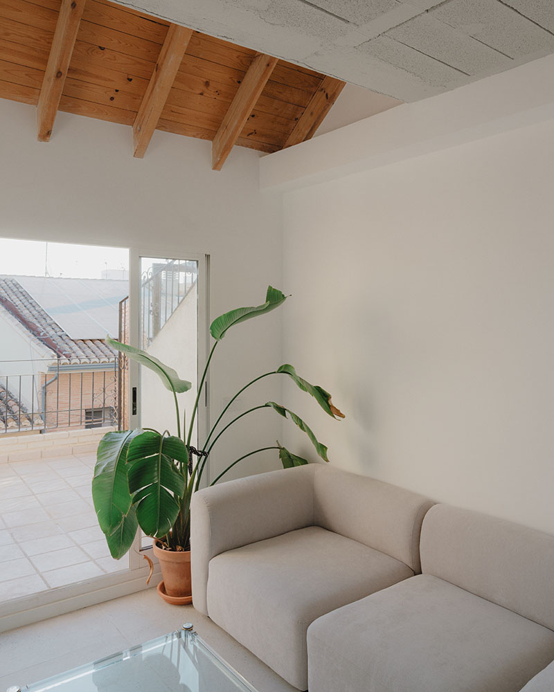 Sala de estar del dúplex en Alboraia de Maria Aucejo, arquitecta, con salida a terraza y techumbre de madera