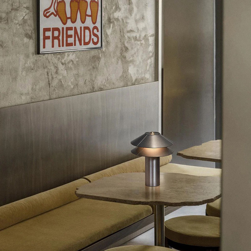 Lámpara portátil 2Shades de Minale en una mesa de un local