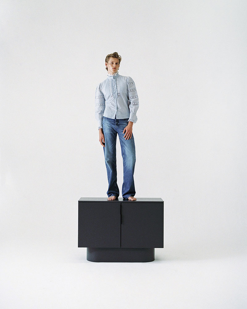 Models Room, editorial de moda y mobiliario: un chico rubio subido encima de un aparador