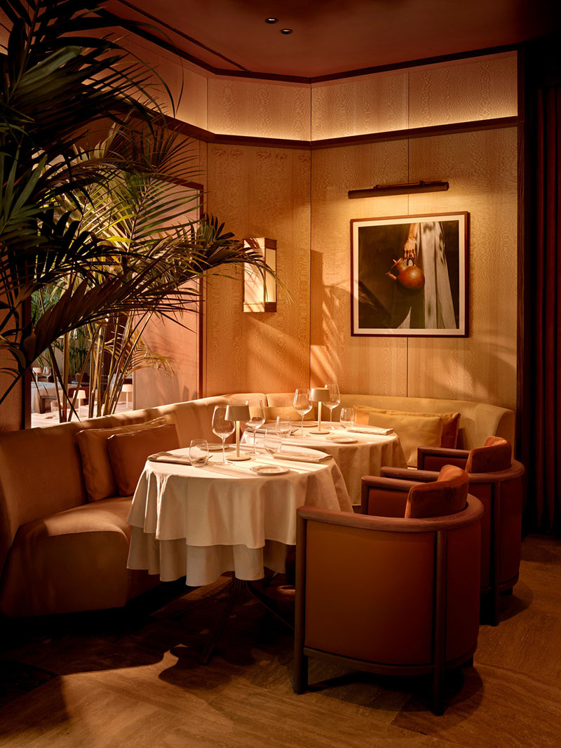 Rincón íntimo del restaurante Esca con mobiliario tapizado y luz cálida diseñado por Urbanjobs