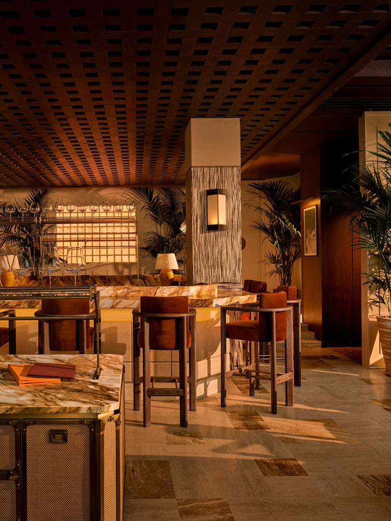 Área de barra alta del restaurante Esca con acabados en mármol y mobiliario de Urbanjobs