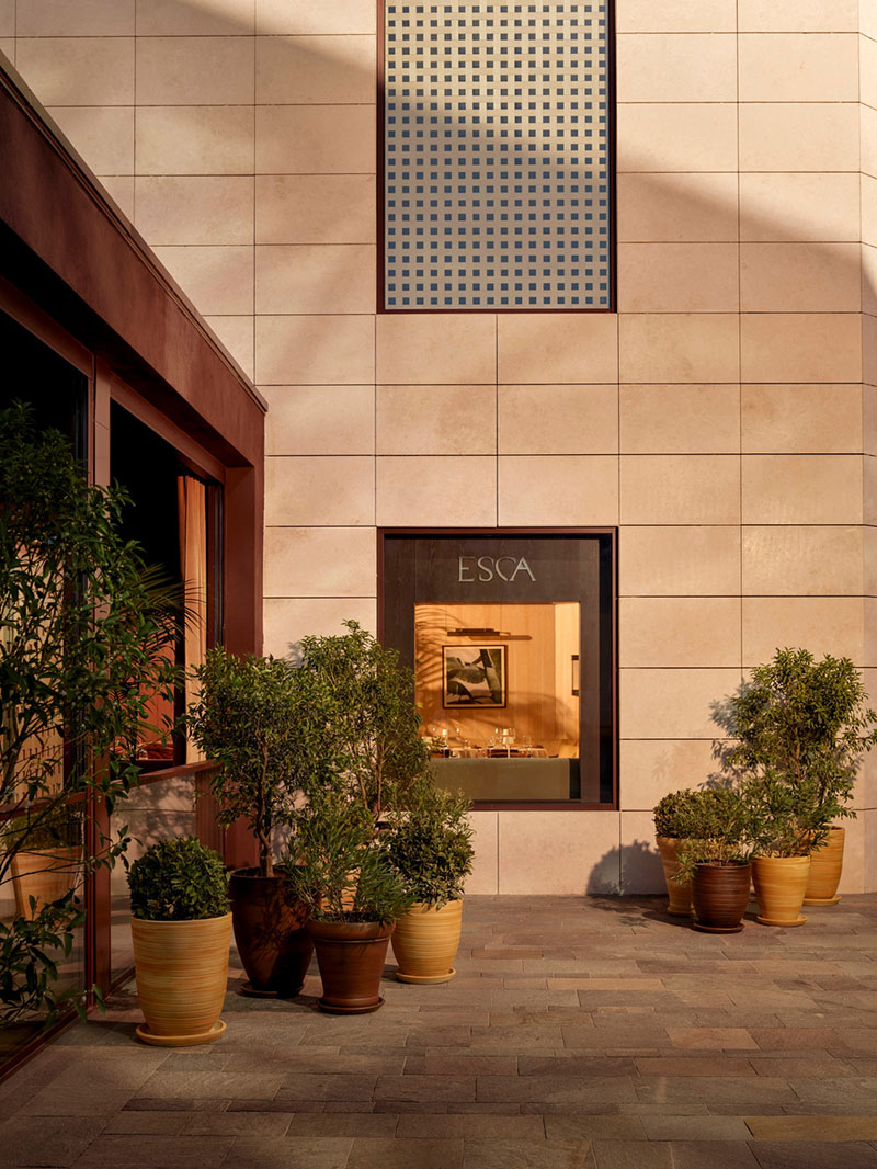 Terraza exterior del restaurante Esca con vegetación y pavimento de piedra diseñada por Urbanjobs