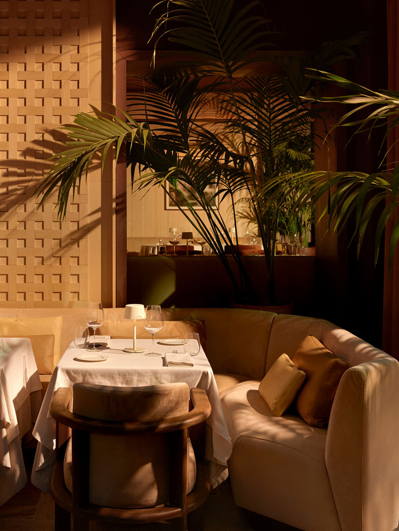 Área de comedor del restaurante Esca con muro calado y vegetación interior proyectada por Urbanjobs