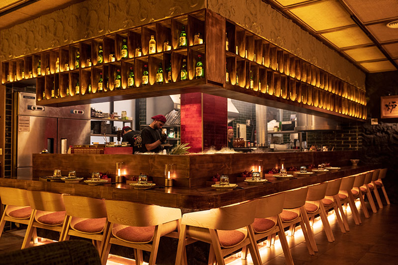 Interior del restaurante Toritama Yakitori con barra central y cocina vista